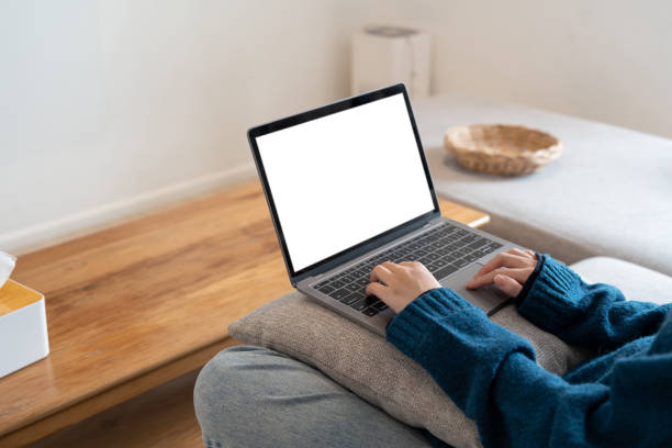 istock Top view mockup image of a woman working and typing on laptop computer with blank screen while sitting on a sofa at home 1444871665
