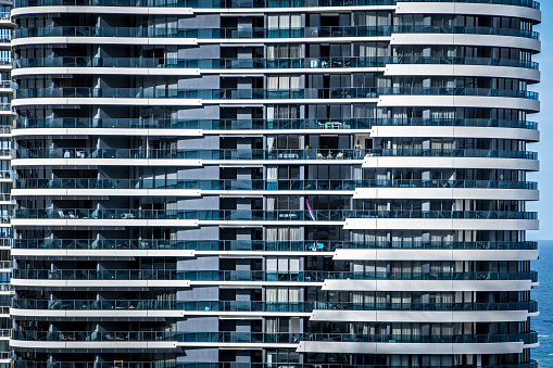 Front view detail of eleven floors of Broadbeach high rise apartment building on Australia's Gold Coast: edited. Symmetry, conformity, repetition  (Taken from balcony of nearby hotel building)