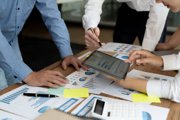 istock Financial analyst analysis business financial report on digital tablet during discussion at meeting of corporate showing the results of their successful teamwork., business meeting concept, Marketing 1444872702