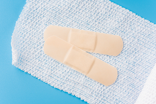 White bandages and plasters on blue background