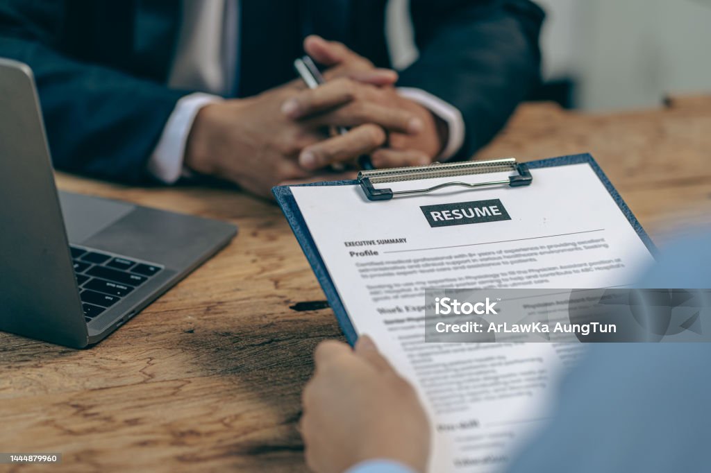 Hiring concept HR manager is interviewing a job candidate filling out a resume on a job application form to be considered for a job Interview - Event Stock Photo
