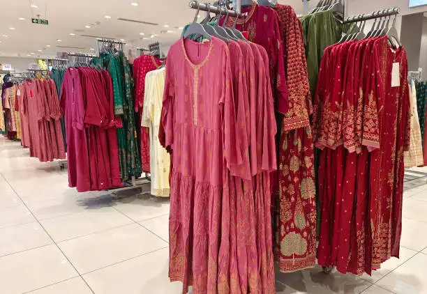 Photo of Female casual clothes in boutique, clothes with a selection of ladies fashion, Colorful women's dresses on hangers in a retail shop in India.