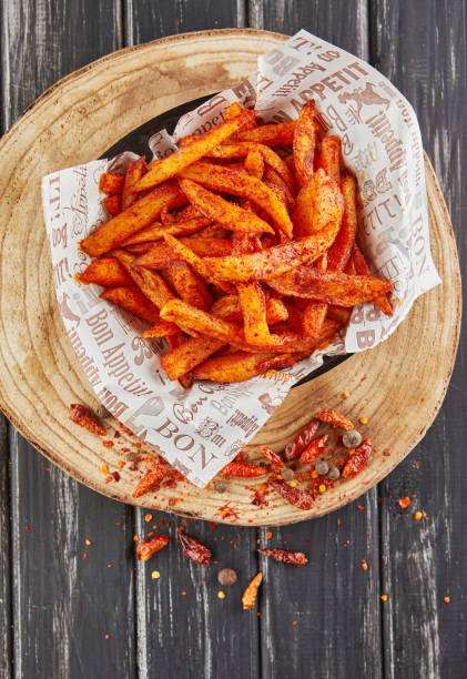 batata frita en aceite con pimienta sobre tabla de madera, sirviendo en cafetería - sweet potato french fries yam baked fotografías e imágenes de stock