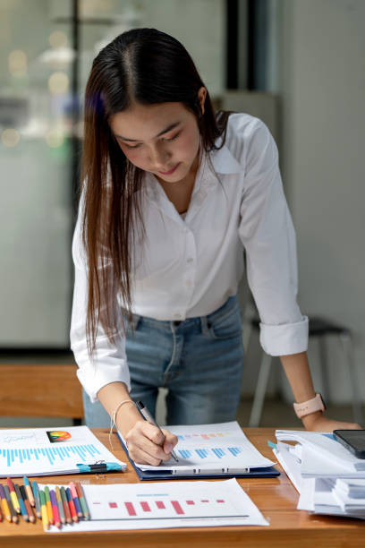 istock Young business woman working on paperwork and statistics graphs. 1444890152