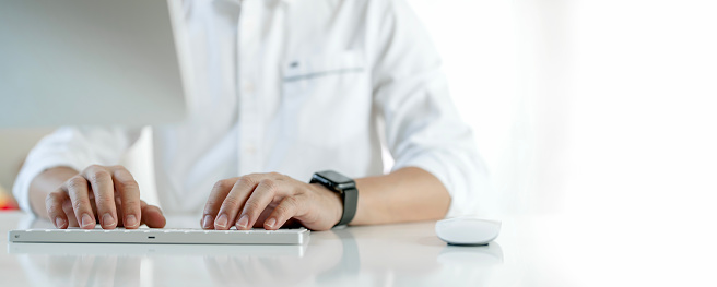 closeup image of man typing on computer keyboard, copy space, banner background.