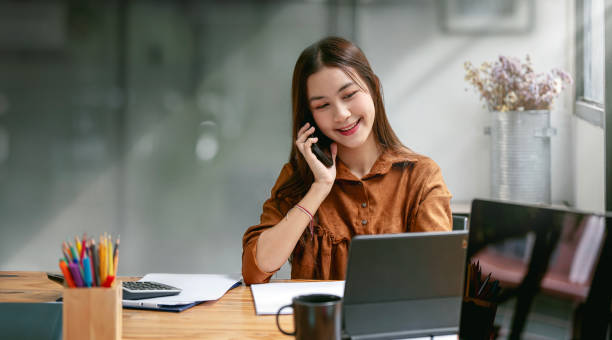 istock Happy businesswoman talking on mobile phone while analyzing weekly schedule in her notebook. 1444891316