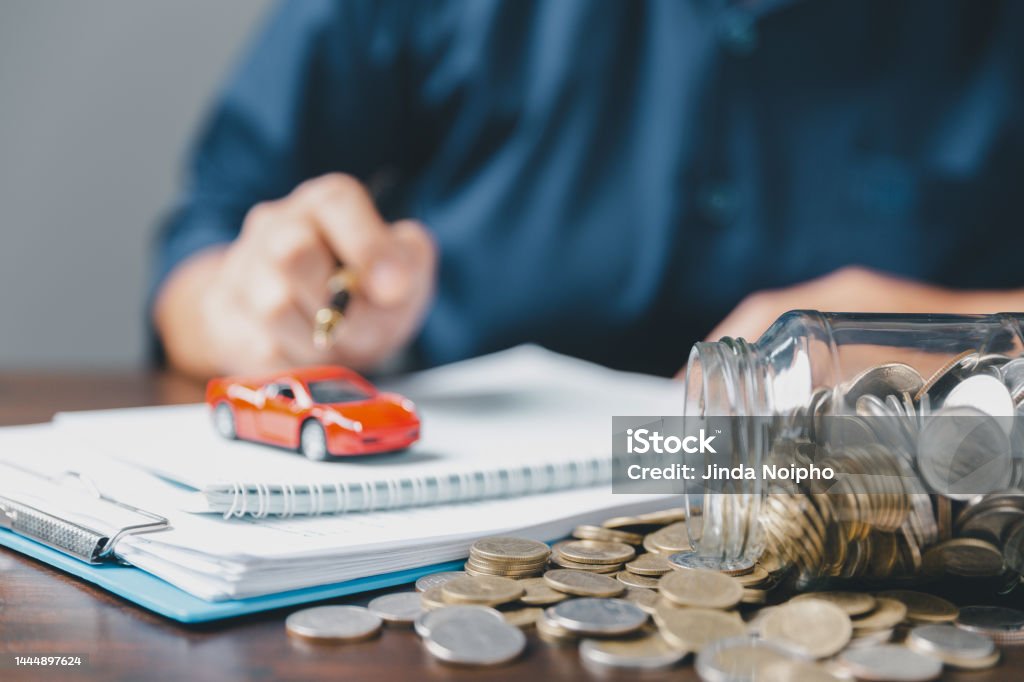 Concept of car insurance business, saving buy - sale with tax and loan for new car. Car toy vehicle with stack coin money on background. Planning to manage transportation finance costs. loan for car Car Insurance Stock Photo