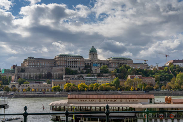 view of the Danube River and the Hungarian Parliament Building with a restaurant ship in the foreground Budapest, Hungary - 4 October, 2022: view of the Danube River and the Hungarian Parliament Building with a restaurant ship in the foreground budapest danube river cruise hungary stock pictures, royalty-free photos & images