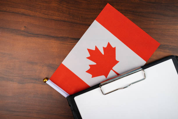 istock mockup for text on clipboard with Canadian flag, white sheet of paper in a folder for notes 1444914256
