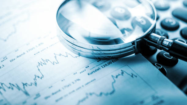 istock Magnifying glass, calculator and charts on paper 1444915259