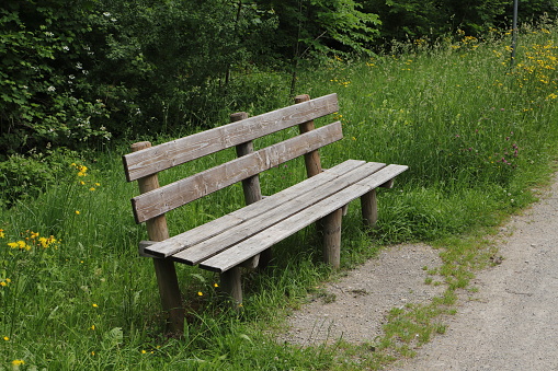 A brown wooden bench in a park