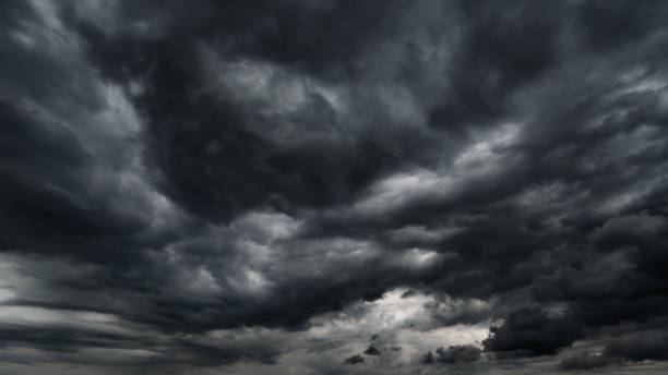istock dark dramatic sky with black stormy clouds before rain or snow as abstract background, extreme weather, the sun shines through the clouds, high contrast photo 1444917236