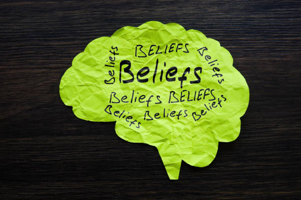 A Paper brain with handwritten words beliefs. Bias concept.