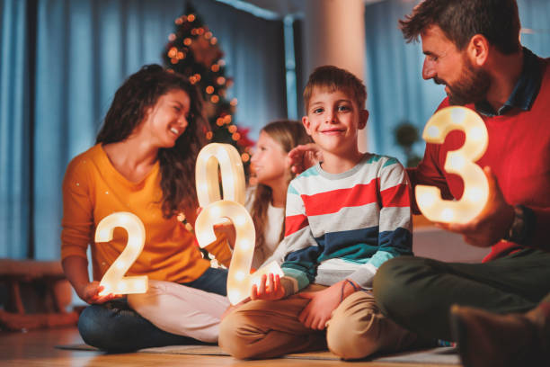 istock Parents and children holding illuminative numbers 2023 while celebrating New Year 1444917574