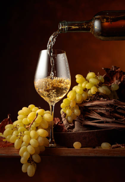 el vino blanco se vierte en una copa. - wine pouring wineglass white wine fotografías e imágenes de stock
