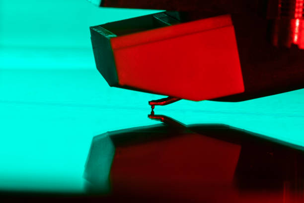 istock Needle on vinyl record on turntable. Macro of turntable needle with colored lights. Turntable needle on vinyl reflecting disco lights. close up view of vinyl grooves are needle 1444920833