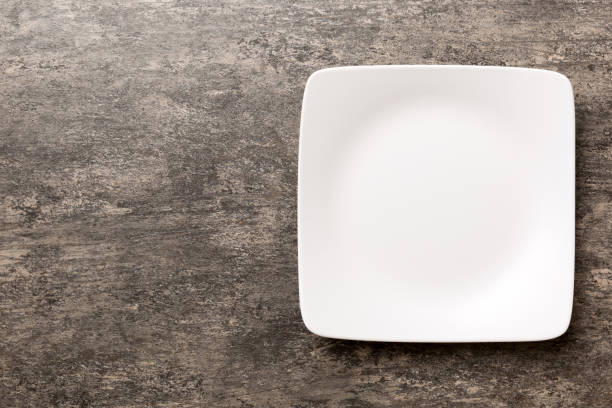 istock Top view of empty square plate on cement background. Empty space for your design 1444922488