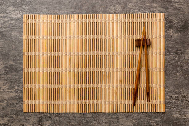 istock Two chopsticks and bamboo mat on cement background. Top view, copy space 1444922493
