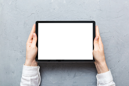 female teen hands using tablet pc with white screen, Mockup image of woman hand holding white tablet pc with blank white screen at home.