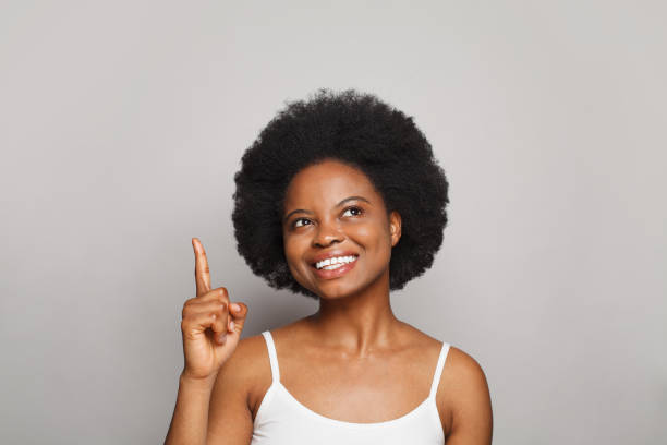 istock Happy woman pointing finger up on white background 1444923743