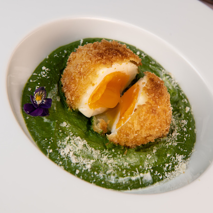 Recipe Breaded soft-boiled eggs and creamed spinach with parmesan. High quality 4K video