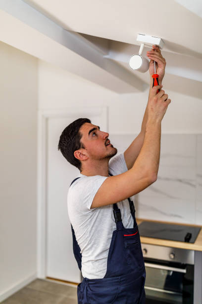 istock A younger maintenance technician is fixing a smoke detector. 1444926412