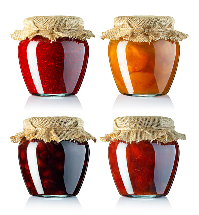 set of fruits jam in glass jars covered with sackcloth isolated on white background