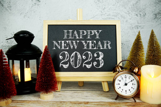 istock Happy New Year 2023 text message with alarm clock, LED candle light and Christmas pine tree 1444928401