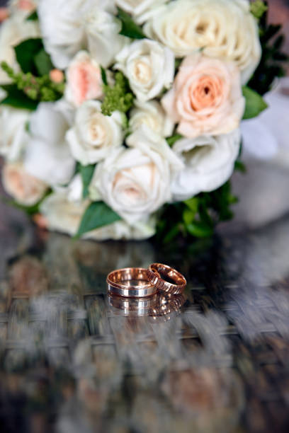 istock Wedding rings and bouquet on background 1444930267