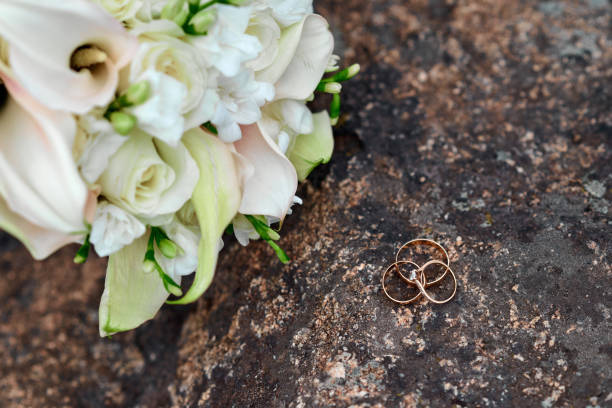 istock Wedding rings and bouquet on background 1444930283