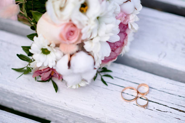 istock Wedding rings and bouquet on background 1444930370