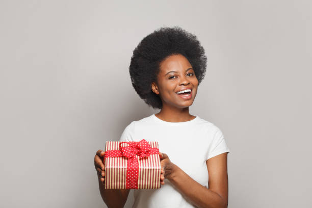 istock Young cheerful woman holding red gift box and having fun on white studio background 1444930721
