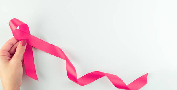 sfondo nastro rosa. simbolo sanitario nastro rosa nelle mani della donna su sfondo bianco. concetto di supporto per il cancro al seno. giornata mondiale contro il cancro. - aids awareness ribbon ribbon bow cut out foto e immagini stock