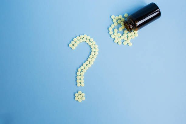 istock Assorted pharmaceutical medicine pills, tablets and capsules and bottle on blue background. Drugs and various narcotic substances. Copy space for text. Stock photo for design. 1444933303