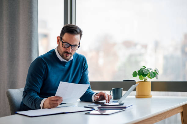 hardworking young adult businessman, checking the company budget in the files. - evrak işleri stok fotoğraflar ve resimler