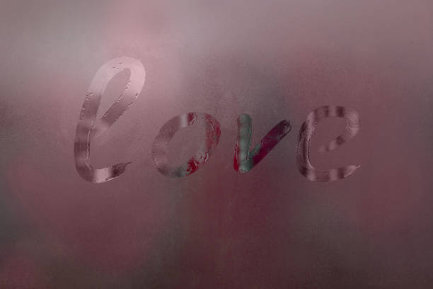 Inscription on misted window: love, abstract red background