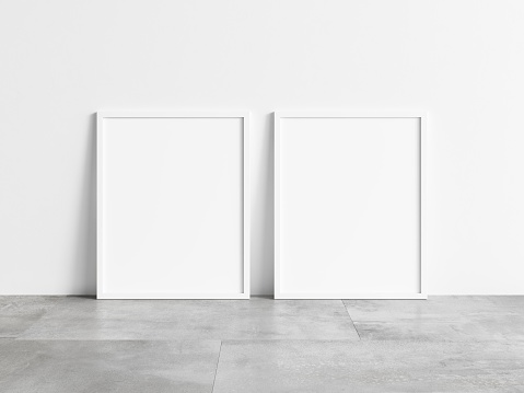Two vertical white frame mock up on concrete floor. Blank two white frame. 3d illustrations.