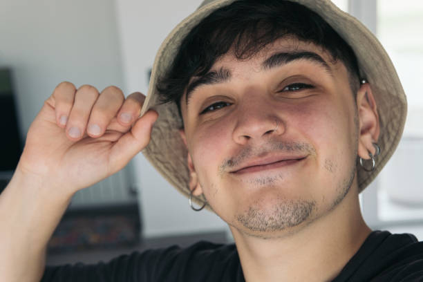 selfie of a handsome young man smiling using a hat