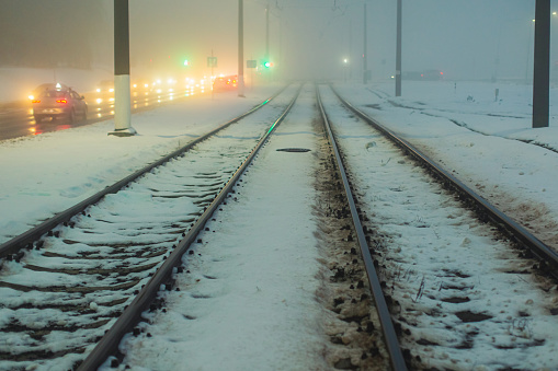 Tram rails. Foggy weather. Night fog. Poor visibility. Ray of light. Snow and ice. City street