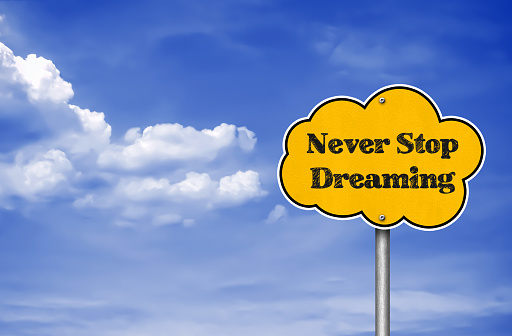 Never stop dreaming - road sign motivational slogan