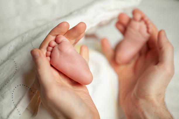istock Baby's feet in daddy's hands 1444957040