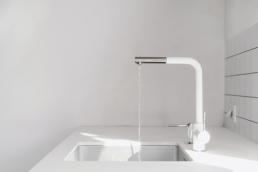 minimalistic style in apartment, white countertop, single wash bowl and mixer with water jet, tile on wall and copy space on background