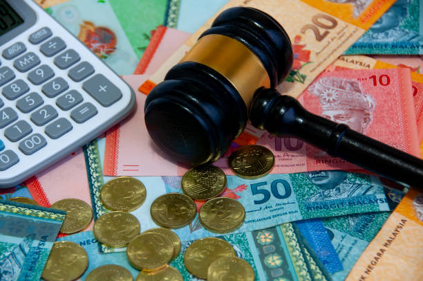 istock Side view of various Malaysia Ringgit currency and coins with gavel and calculator. 1444959347