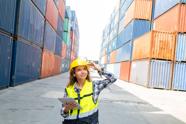 istock Professional worker in helmet and uniform inspecting cargo at freight container shipping company before being exported to the port 1444959559