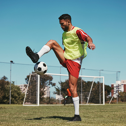 Soccer, training and man with ball on soccer field for fitness, workout and sports practice. Football, energy and skill by professional athlete enjoy sport routine with soccer ball at football field