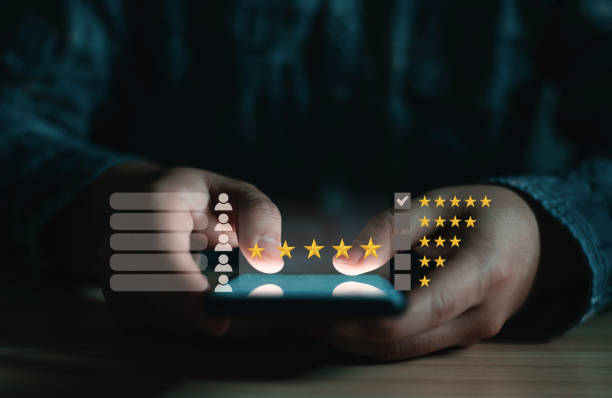 istock Man holding smartphone with five-star pop-up icon for customer service experience, feedback review satisfaction, and business satisfaction survey. 1444971199