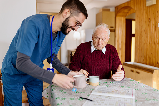 Home caretaker – man helping senior man