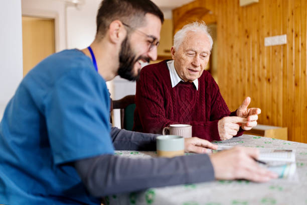 caretaker with senior man enjoying coffee break - community outreach home caregiver care cheerful imagens e fotografias de stock