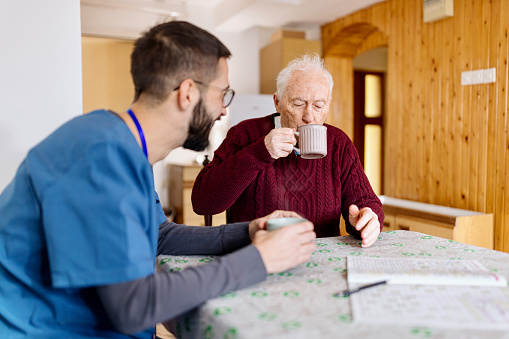 Home caretaker – man helping senior man
