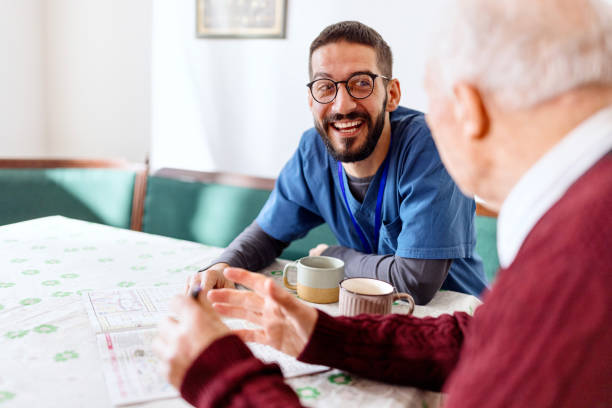 istock Caretaker with senior man enjoying coffee break 1444971334